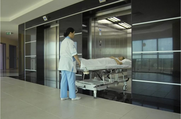 Nurse transporting patient on stretcher into hospital elevator